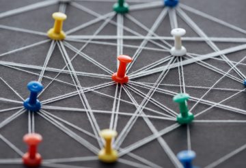 colorful push pins connected with strings isolated on grey, network concept